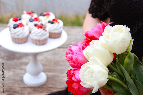 Homemade pavlovas cupcakes with berries and tulips