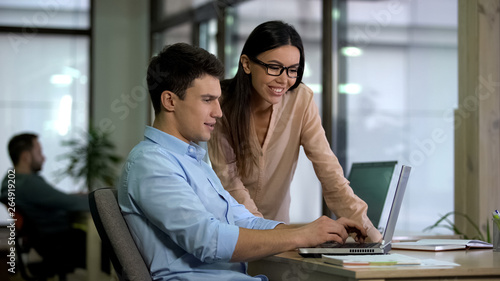 Female chief editor controlling work of young male journalist, approving article