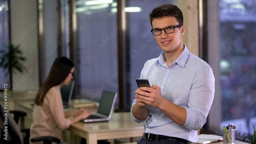 Man smiling on camera with smartphone in hands, earning money in mobile app Man smiling on camera with smartphone in hands, earning money in mobile app