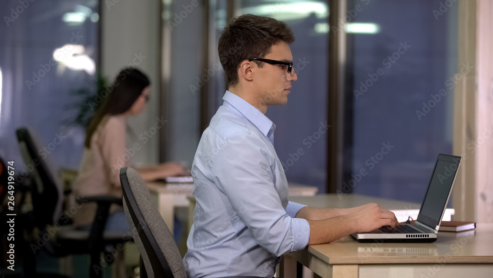 Two people working on laptop in big office, technical support, service center