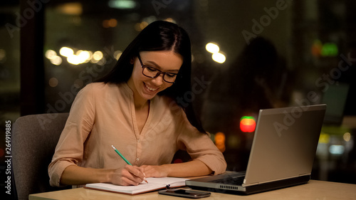 Young woman writing ideas into notebook, thinking plot of book, inspiration