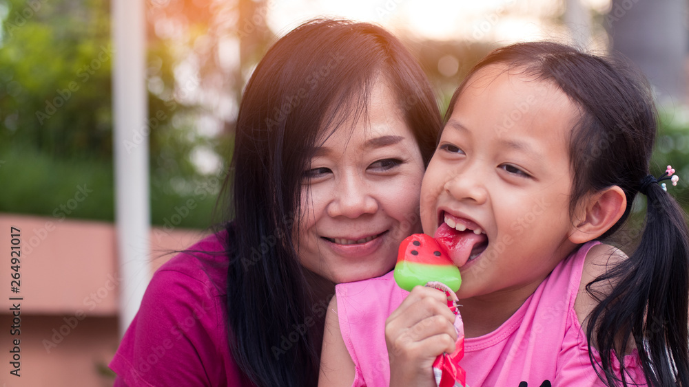 Asian mother and her daughter smiling with eating ice cream Asian mother and her daughter smiling with eating ice cream