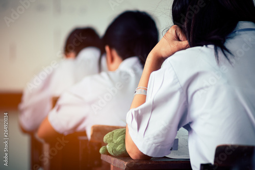 Back of students taking exam with stress in classroom