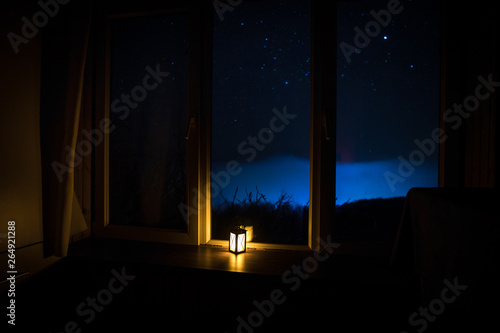 Night scene of stars seen through the window from dark room. Night sky inside dark room. Long exposure shot