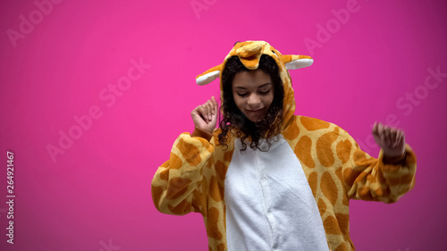 Afro-American woman in funny giraffe pajamas dancing isolated on pink background