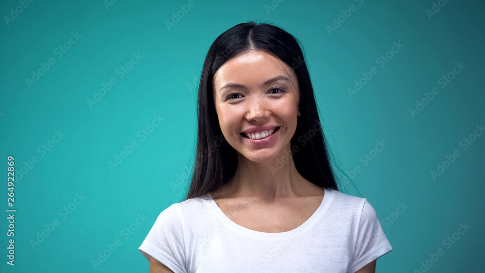 Fototapeta premium Portrait of beautiful asian woman looking at camera, isolated on blue background