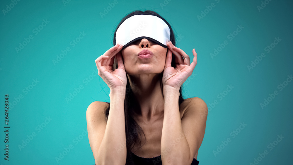 Woman in blindfold doing air kiss, flirting with admirer and having fun, joy Woman in blindfold doing air kiss, flirting with admirer and having fun, joy