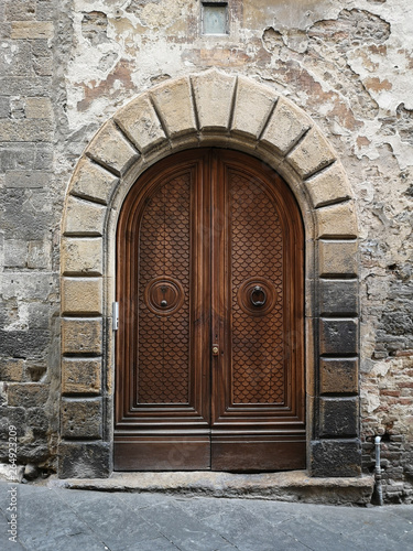 Ancient wooden portal with stone arch of an Italian medieval fortress.