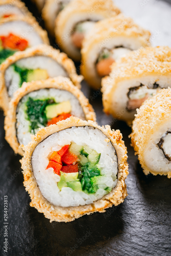 sushi, japanese food, deluxe restaurant menu, delicious traditional seafood. philadelphia and vegetarian tempura sushi rolls, served on black plate