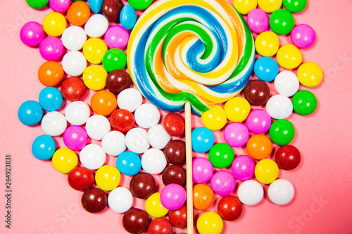 Colorful lollipops and different colored round candy. Top view blue pastel background