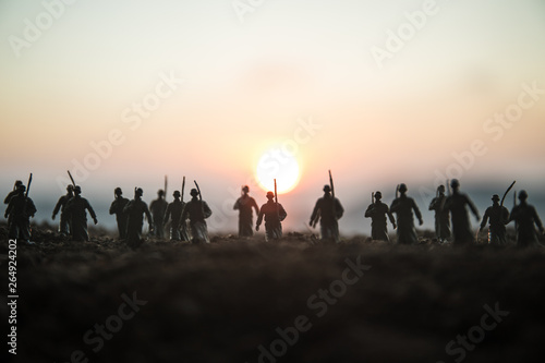 War Concept. Military silhouettes fighting scene on war fog sky background  World War Soldiers Silhouettes Below Cloudy Skyline at sunset. Attack scene. Armored vehicles.