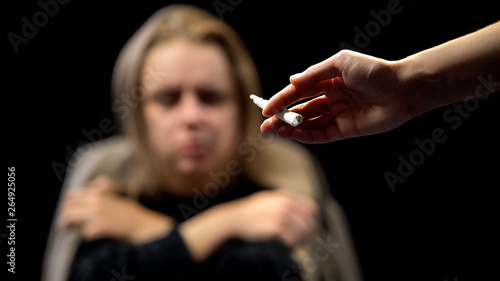Hand offering weed to depressed homeless woman, drug addiction, temptation photo