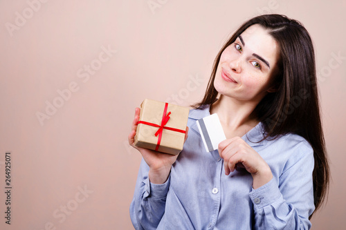 Gift buying season, shopping, buying presents, celebration and greeting concept. Happy cheerful woman with gift box and credit card