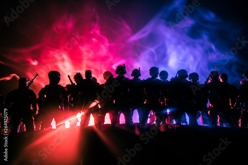 Anti-riot police give signal to be ready. Government power concept. Police in action. Smoke on a dark background with lights. Blue red flashing sirens.