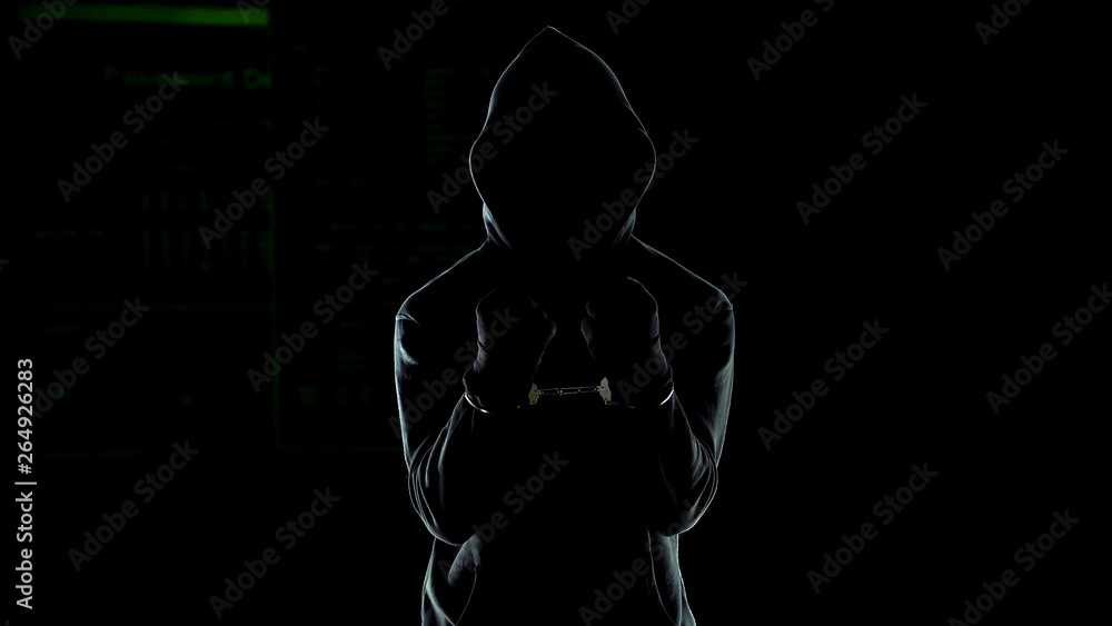 Handcuffed male in hoodie showing hands, dangerous serial killer punished by law