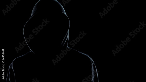 Close up of faceless male silhouette standing against black background, criminal photo