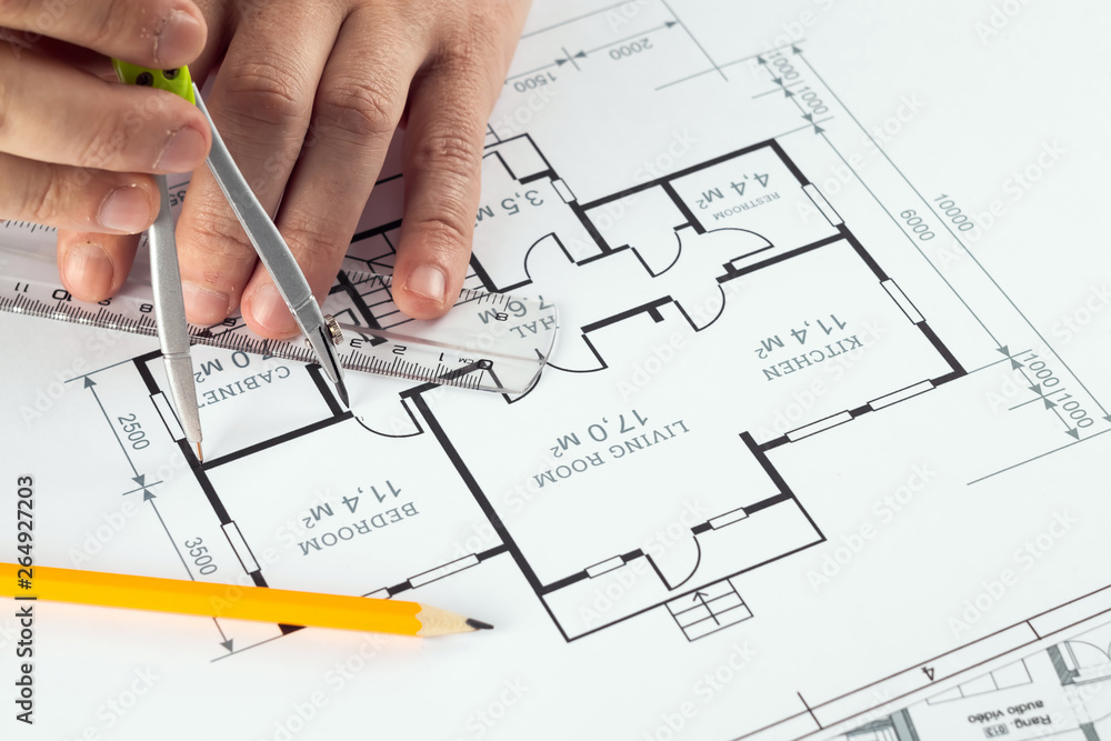 Male hands, Orange helmet, pencil, architectural construction drawings, tape measure. The architect designs the building. The concept of architecture, construction, engineering, design. Copy space. Male hands, Orange helmet, pencil, architectural construction drawings, tape measure. The architect designs the building. The concept of architecture, construction, engineering, design. Copy space.