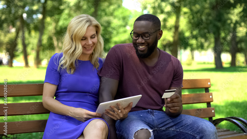 Couple booking tickets online using tablet, credit card payment, banking Couple booking tickets online using tablet, credit card payment, banking