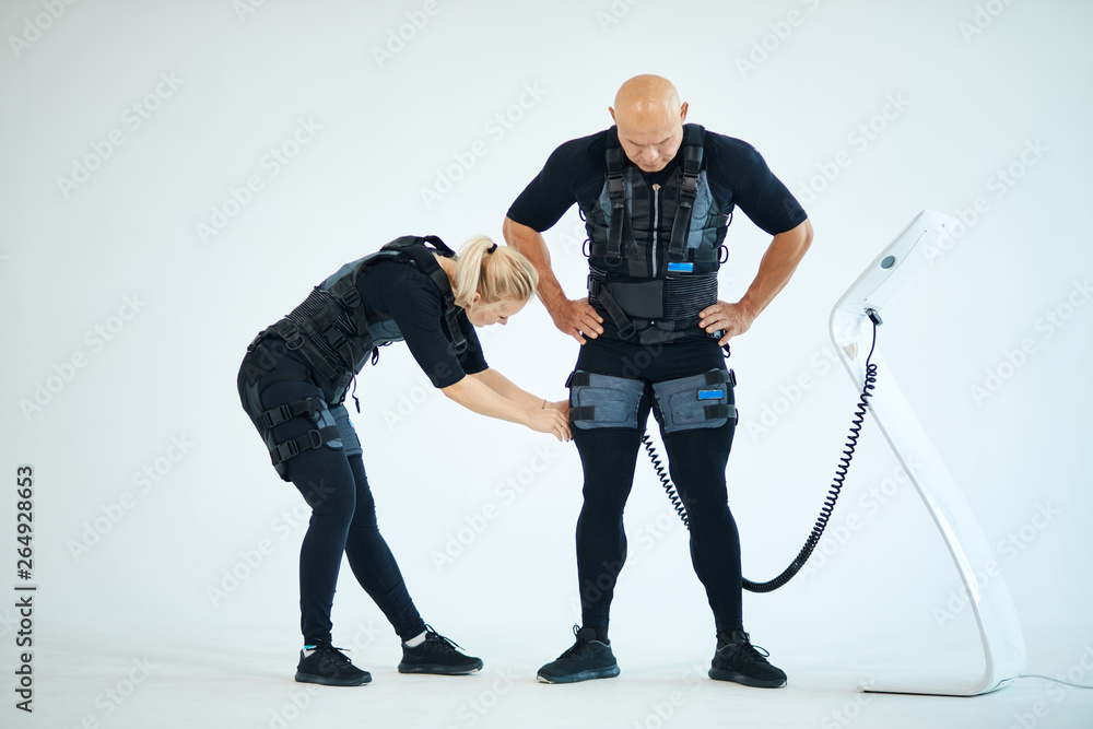 woman preparaing man for fitness training. full length photo. isolated ...