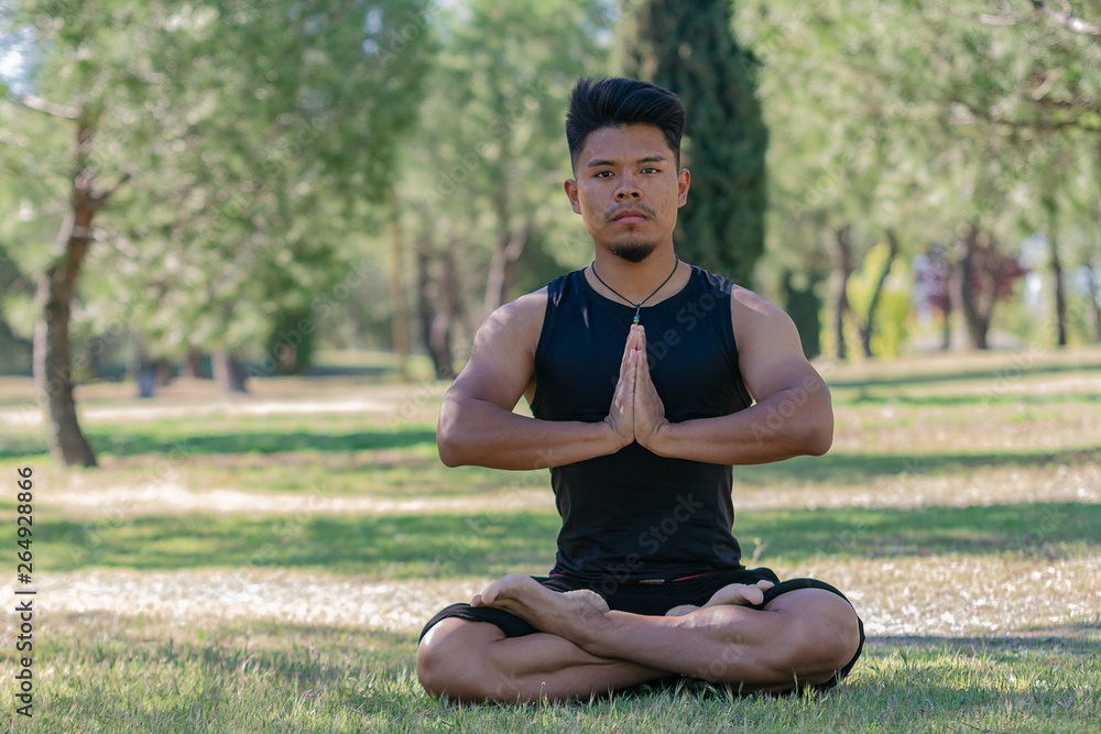 Fototapeta premium latin man doing yoga in the park