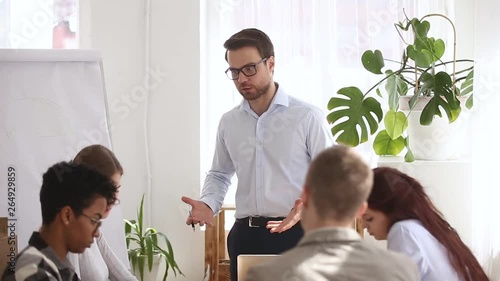 Angry boss shouting at group office meeting scolding criticizing employees