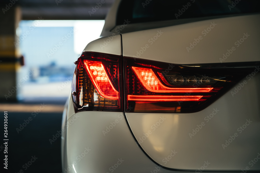 Obraz premium Modern car safe red led taillights in the parking lot