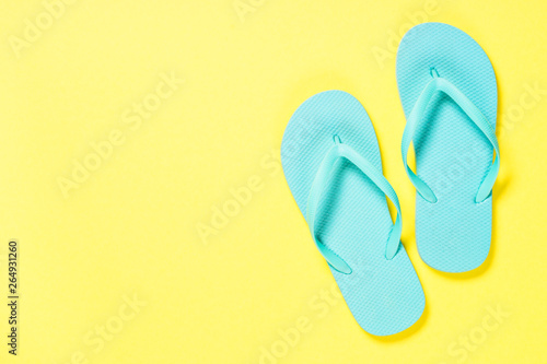 Blue flip flops on yellow background.
