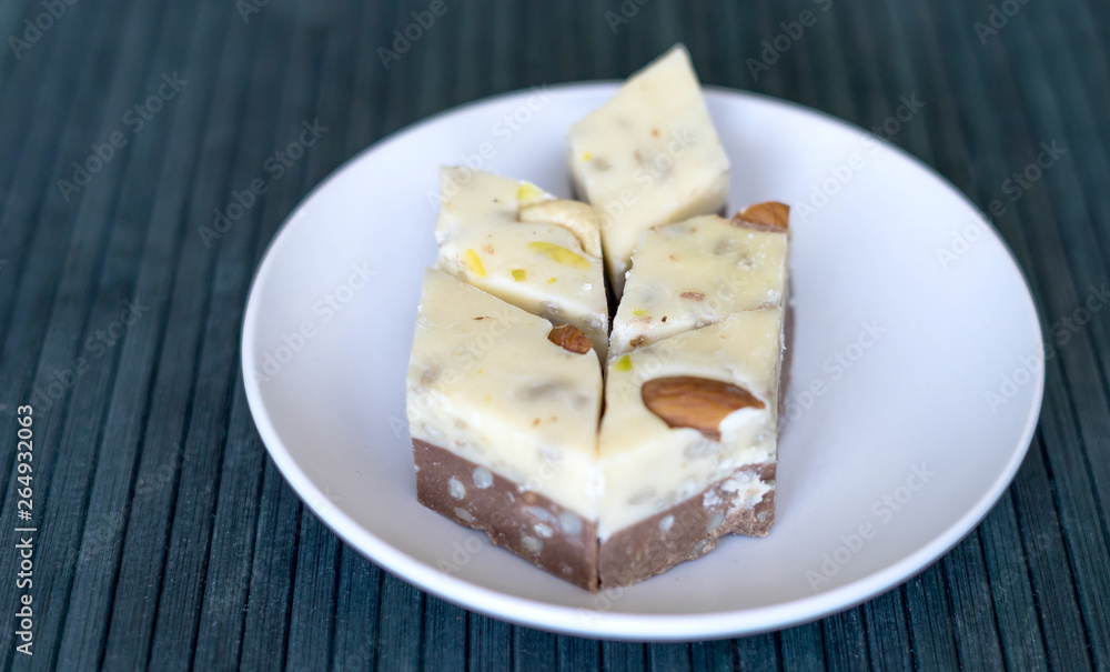 Traditional Turkish Delight. Oriental dessert halva on a  plate. Isolated on background. Eastern delicacy sweets. Healthy food. Nuts mix assortment. image close up nuts, pistachios, almond, cashew nut