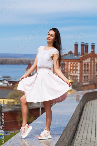 Young brunette woman in pink skirt and white blouse