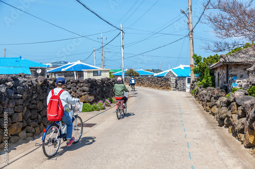Tourists ride a bicycle along a street on Udo Island, a trip to South Korea photo