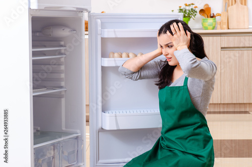 Canvastavla Young woman cleaning fridge in hygiene concept