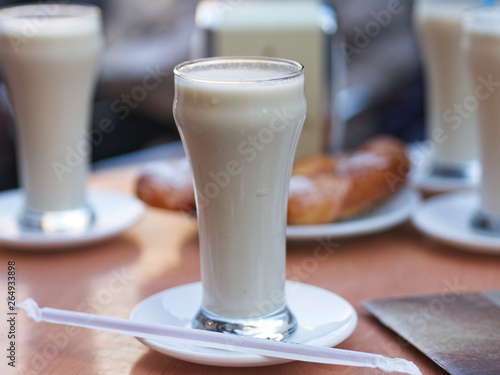 Glasses of Horchata de Chufa on a wooden table. It is a Mediterranean tradition of grain-based beverages and is made with dried and sweetened tiger nuts.