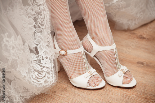 bride in white shoes and dress indoors
