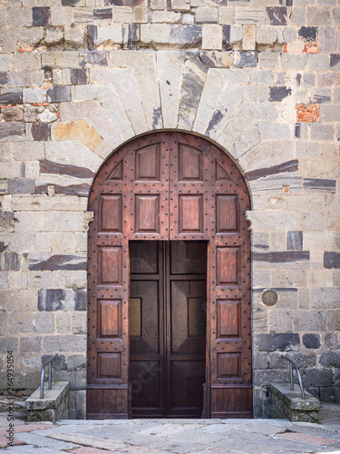 Ancient wooden portal with stone arch of an Italian medieval fortress.