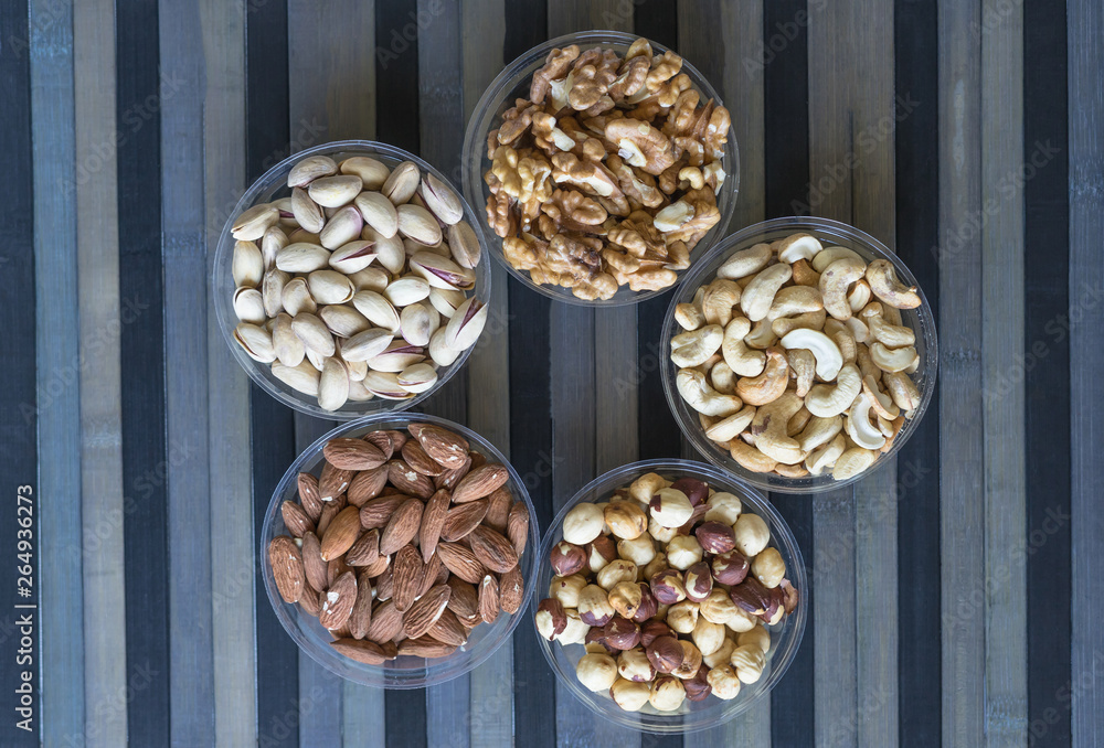 Obraz premium Healthy food. Nuts mix assortment on stone texture top view. Collection of different legumes for background image close up nuts, pistachios, almond, cashew nuts, peanut, walnut. image