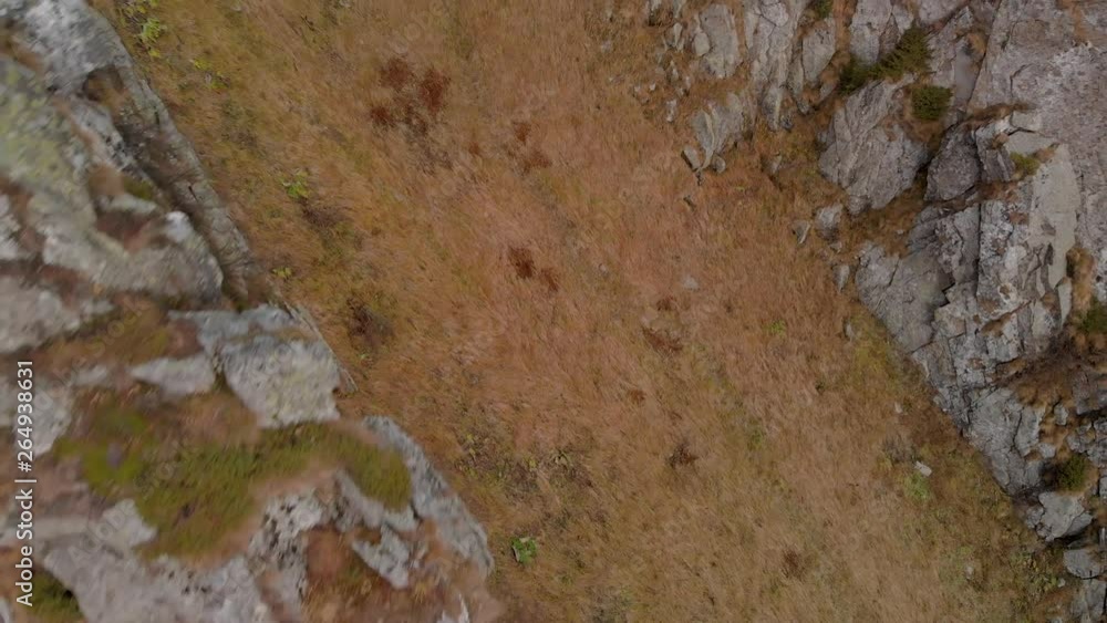 Aerial drone unveiling mountain peak from behind a ridge covered in cliffs Aerial drone unveiling mountain peak from behind a ridge covered in cliffs