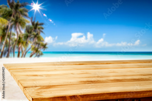 Summer table background of free space for your decoration and landscape of beach with palms. 