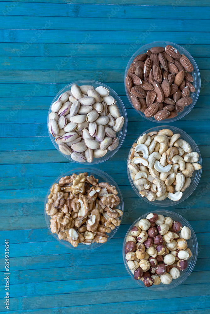Healthy food. Nuts mix assortment on stone texture top view. Collection of different legumes for background image close up nuts, pistachios, almond, cashew nuts, peanut, walnut. image Healthy food. Nuts mix assortment on stone texture top view. Collection of different legumes for background image close up nuts, pistachios, almond, cashew nuts, peanut, walnut. image