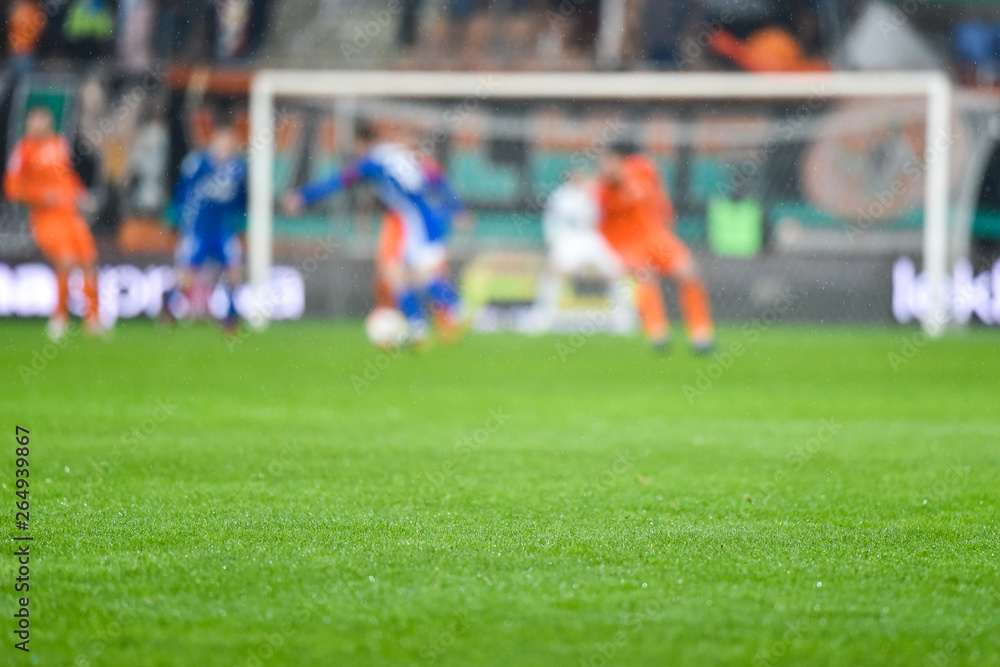 Grass on the football pitch with match in the background. Grass on the football pitch with match in the background.