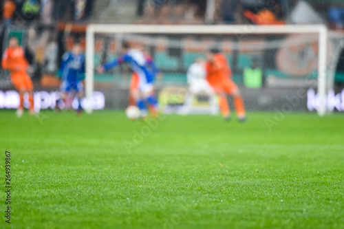 Grass on the football pitch with match in the background.