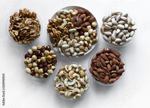 Healthy food. Nuts mix assortment on white grey table top view. Collection of different legumes for background image close up nuts  pistachios  almond  cashew nuts  peanut  walnut. image