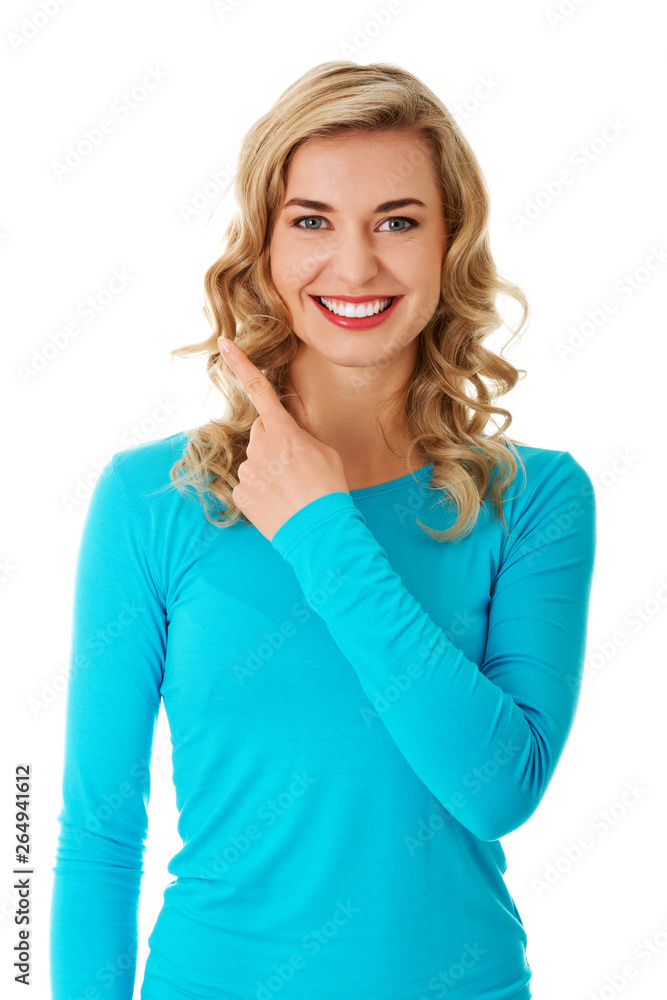 Blond woman in blue clothes showing finger up standing and on white background. Blond woman in blue clothes showing finger up standing and on white background.