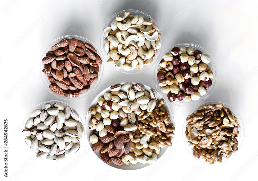 Healthy food. Nuts mix assortment on white grey table top view. Collection of different legumes for background image close up nuts, pistachios, almond, cashew nuts, peanut, walnut. image Healthy food. Nuts mix assortment on white grey table top view. Collection of different legumes for background image close up nuts, pistachios, almond, cashew nuts, peanut, walnut. image