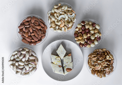  Oriental dessert halva with pistachio, almond, cashew nuts, peanut, walnut on a plate. Image. Healthy food. Nuts mix assortment. sweets, Turkish Delight. Isolated background.. Eastern delicacy