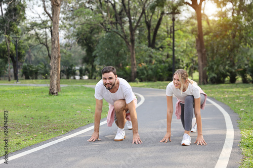 a runner caucasian couple is at starter for jogging in the park during summer season with smile (healthy or sport concept)
