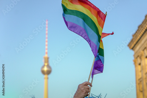 Photography LOW ANGLE VIEW OF HAND HOLDING RAINBOW FLAG DURING CSD-PARADE IN BERLIN
