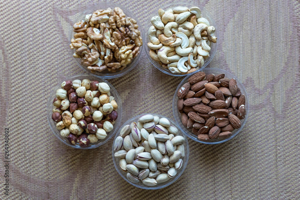 Healthy food. Nuts mix assortment on stone texture top view. Collection of different legumes for background image close up nuts, pistachios, almond, cashew nuts, peanut, walnut. image Healthy food. Nuts mix assortment on stone texture top view. Collection of different legumes for background image close up nuts, pistachios, almond, cashew nuts, peanut, walnut. image