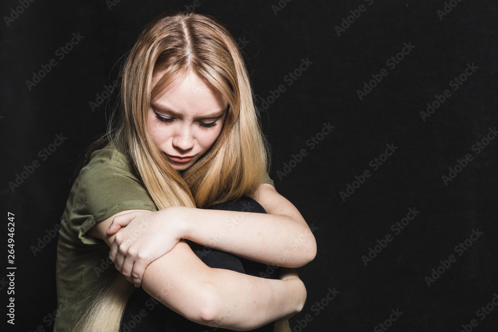 Sad young woman going to cry in a black background Sad young woman going to cry in a black background