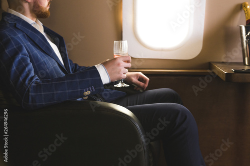 фотографія A young successful businessman in an expensive suit sits in the chair of a priva