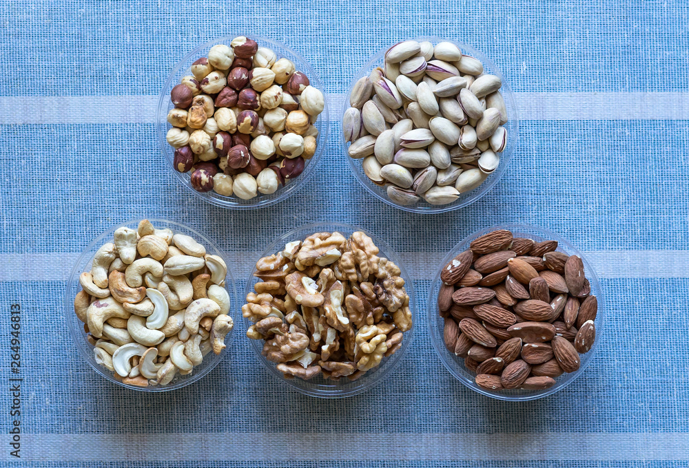 Healthy food. Nuts mix assortment on stone texture top view. Collection of different legumes for background image close up nuts, pistachios, almond, cashew nuts, peanut, walnut. image Healthy food. Nuts mix assortment on stone texture top view. Collection of different legumes for background image close up nuts, pistachios, almond, cashew nuts, peanut, walnut. image